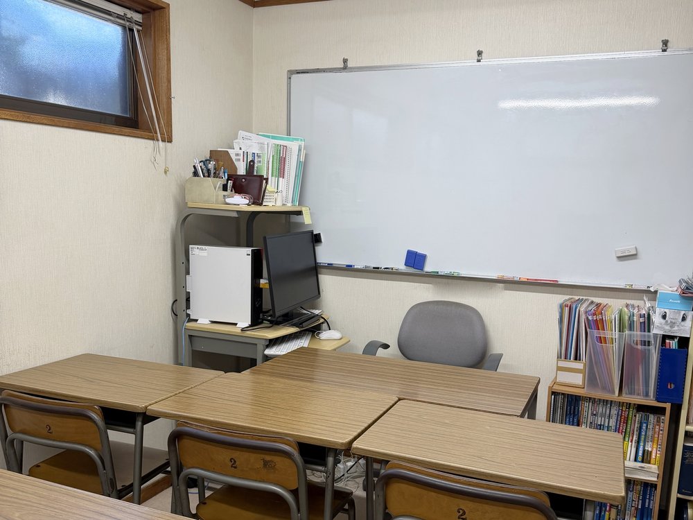 机が並ぶ明るい教室